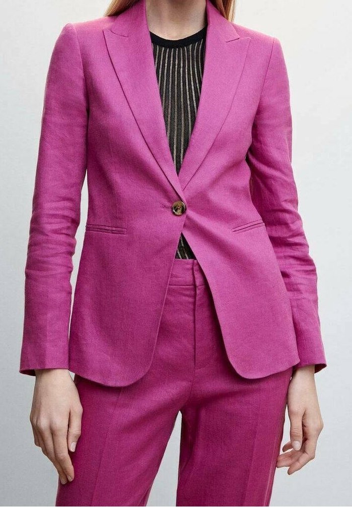 Costume fuchsia en lin, avec une fermeture à un seul bouton, des revers nets, et un pantalon slim, assorti à un haut noir à rayures.