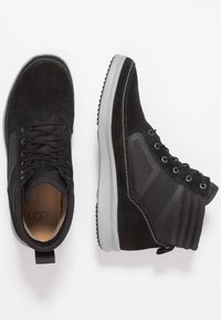 Černé semišové a síťované tenisky s gumovou podrážkou, s šedými akcenty a švy, vysoký design s poutkem na patě.