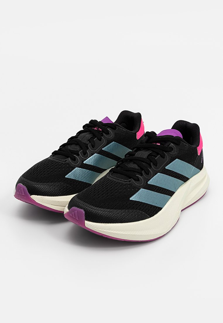 Zapatillas deportivas negras con rayas azul claro, acentos rosas, parte superior de tela texturizada y una entresuela blanca acolchada con una suela morada.
