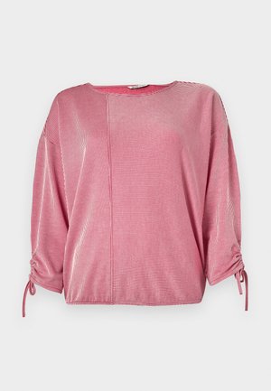 Top rayé rouge et blanc avec un col rond, des manches trois-quarts et des détails froncés élastiqués aux manches. Texture de tissu lisse.