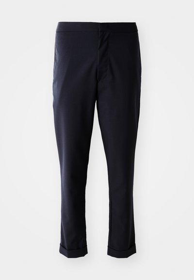 Pantalones azul marino con una tela suave, corte recto, cintura media y puños enrollados. Sin bolsillos visibles ni detalles de metal.