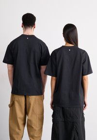 Salomon ALL THAT RIDEZ TEE UNISEX - Μπλουζάκι με στάμπα - deep black