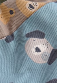 Zachte geribbelde stof met schattige hondenkopjes in beige, bruine en blauwe tinten die een speels patroon vormen.
