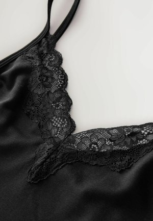Svart camisole med en delikat spetsdetalj längs den V-formade halsringningen och smala justerbara band, med en slät satinliknande tygtextur.