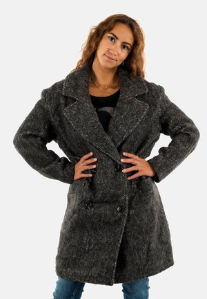 Abrigo de doble pecho en tejido de espiga gris oscuro, con solapas anchas, grandes botones y bolsillos, con un ajuste relajado y oversize.