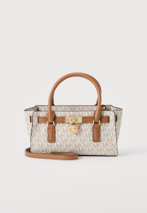 Sac à main beige et marron de créateur avec motif monogramme, doubles poignées, bandoulière amovible et détail de fermeture dorée à l’avant.