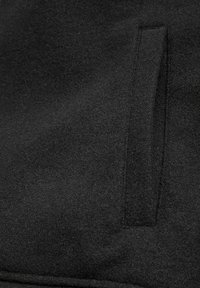 Black fabric with a smooth texture, featuring a concealed pocket in a simple, minimalist design. Uniform color with no visible patterns.