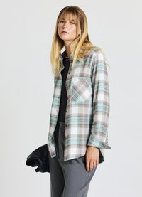 Camicia a quadri in blu chiaro, marrone e bianco. Maniche lunghe, design con bottoni a tutta lunghezza e taschino sul petto. Tessuto morbido e leggero.