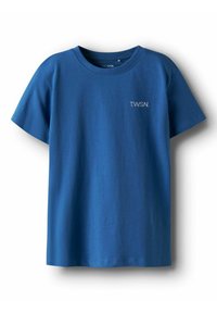 T-shirt en coton bleu à manches courtes, col rond, avec un petit logo blanc "T.W.S.N." sur la poitrine. Texture lisse, design décontracté.