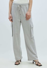 Grijze, elastische cargobroek met een trekkoord in de taille, zijzakken en een losse pasvorm. Het materiaal lijkt zacht met een fleecetextuur.