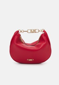 Sac à main en cuir rouge avec une forme arrondie, quincaillerie dorée et une poignée en chaîne ornée des initiales "MK." Fermeture éclair sur un côté.