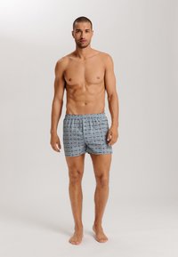 Shorts en tissu léger, avec un motif géométrique bleu et des accents blancs, taille élastique et coupe décontractée.