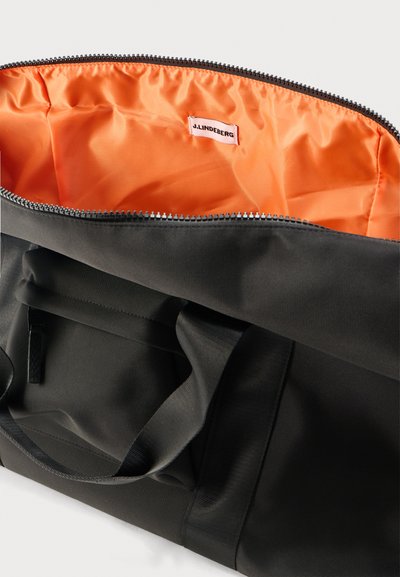 Μαύρη τσάντα ώμου με φαρδιές λαβές, ανοιχτό φερμουάρ στην κορυφή που αποκαλύπτει το φωτεινό πορτοκαλί εσωτερικό επένδυση και ετικέτα J.LINDEBERG στο εσωτερικό.