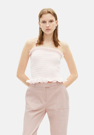 Lichtroze strapless top met geplooide textuur en een gerimpelde zoom, gecombineerd met lichtroze high-waisted broeken met zijzakken.