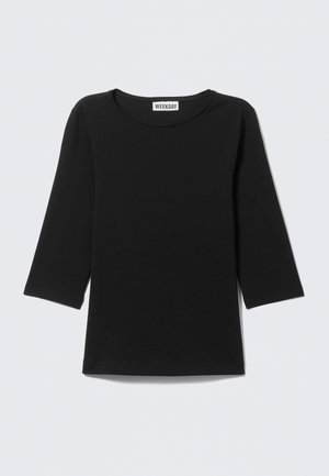 T-shirt noir à col rond avec manches longues remontées aux trois quarts, portant l'étiquette "WEEKDAY" au niveau de l'encolure sur un fond clair uni.