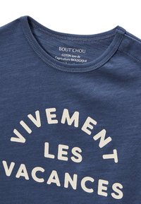 T-shirt en coton bleu foncé avec un texte blanc en design courbé indiquant "VIVEMENT LES VACANCES." Encolure classique avec bords cousus.