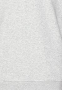 Vaaleanharmaa collegepaita, jossa on pehmeä, teksturoitu kangas. Hihansuut ovat resorilliset ja helmassa on myös resori. Ei näkyviä kuvioita.