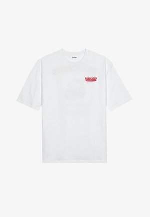 Witte katoenen t-shirt met korte mouwen, ronde hals en een rode grafische tekst "LEKKER VERFRISSEND FRUIT" aan de voorkant.