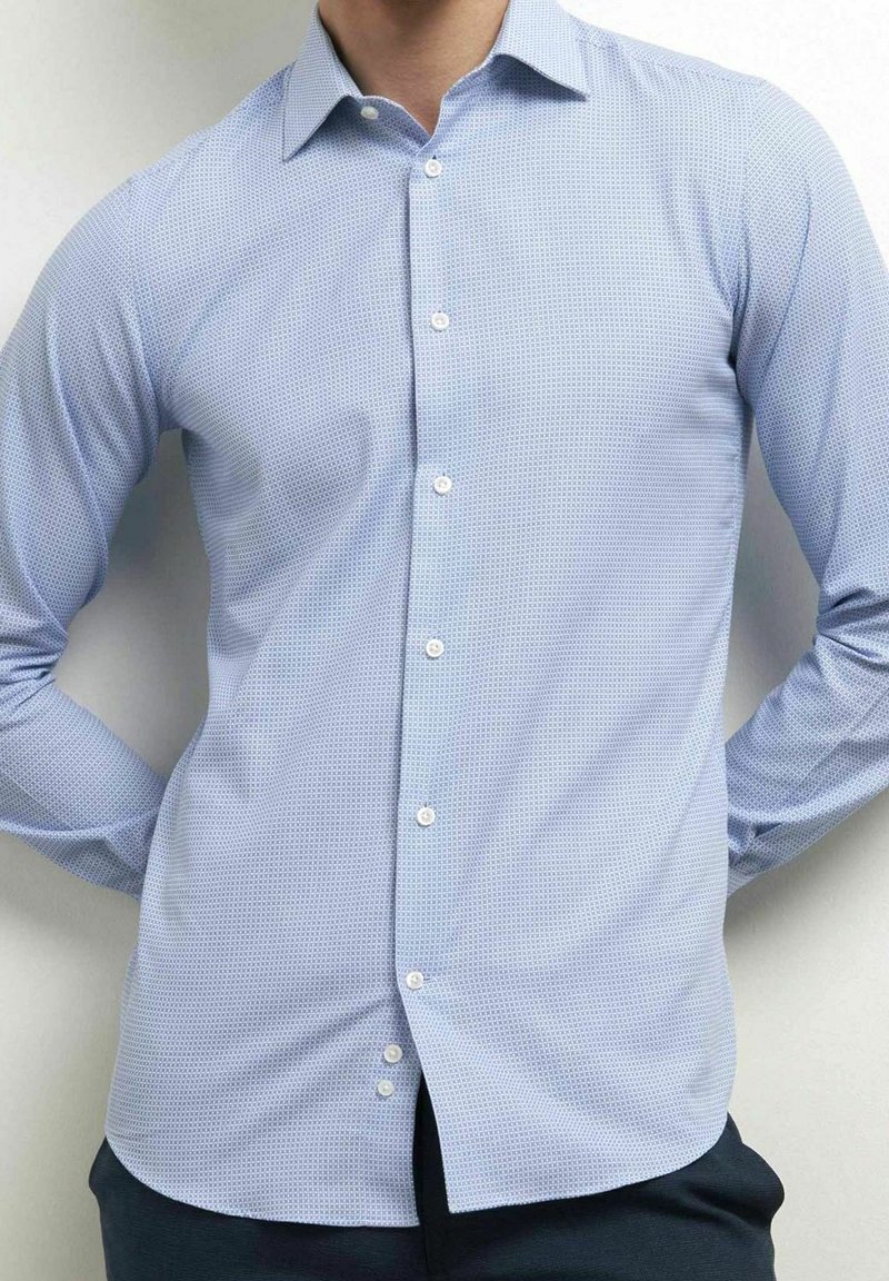 Lichtblauw button-up shirt met een gestructureerd patroon, lange mouwen, een puntige kraag en een ronde zoom. Witte knopen zorgen voor contrast.