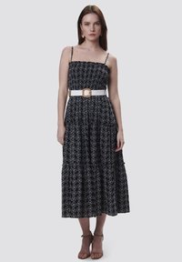 Zwart-witte midi-jurk met bloemenprint, een aansluitend lijfje, een gelaagde rok en een witte riem met vierkante gesp. Dunne verstelbare bandjes.