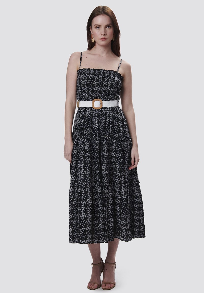 Zwart-witte midi-jurk met bloemenprint, een aansluitend lijfje, een gelaagde rok en een witte riem met vierkante gesp. Dunne verstelbare bandjes.
