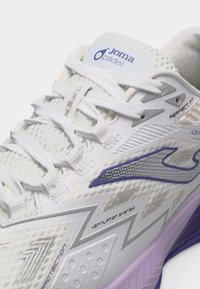 Λευκό αθλητικό παπούτσι Joma για Padel με σύστημα αερισμού, σχέδιο ζιγκ-ζαγκ και δίχτυ, λευκά κορδόνια και μοβ λεπτομέρειες στην σόλα.