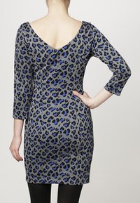 Robe grise avec un décolleté en V profond, des manches 3/4 et un imprimé léopard noir et bleu. Silhouette ajustée et longueur genou. Texture douce.