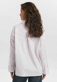 Striped button-up shirt in light pink with thin blue lines, features a relaxed fit, long sleeves, and a rounded hem with buttoned cuffs.