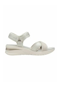 Sandales compensées légères en blanc et crème avec des sangles élastiques polyvalentes et une semelle intérieure texturée et confortable. Semelle légèrement surélevée.