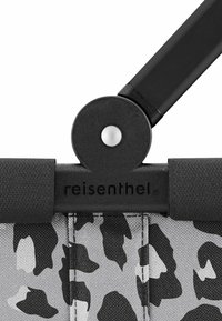 Bolso Reisenthel con tela en estampado de leopardo negro y gris, que presenta una conexión de hardware negra, un botón circular y un asa resistente.