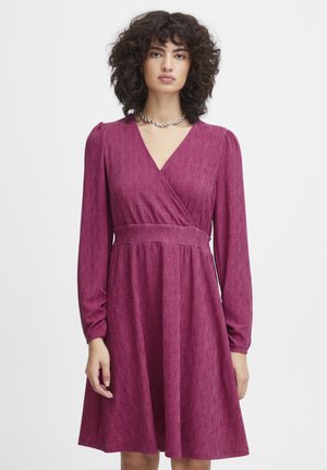 Fuchsia Wickelkleid mit langen Ärmeln, gerippter Textur und definiertem Taillenschnitt. Verfügt über einen V-Ausschnitt, einen schwingenden Rock und einen dezenten Glanz.