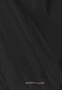 Svart atletisk tyg med en slät textur, med kurviga sömdetaljer och varumärket "ENDURANCE" tryckt i reflekterande silver.