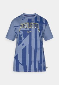 Blå bomulds T-shirt med grafisk design, der har gul "ATLET" tekst, marine blå detaljer og mønstre af stjerner og geometriske former.