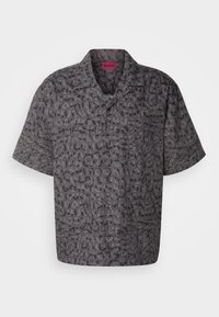 Korte mouwen shirt in donkergrijze stof met contrasterende zwarte grafische letters. Knopsluiting aan de voorkant met kraag; relaxte pasvorm. Subtiele textuur.
