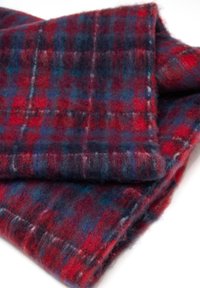 Bufanda de lana con un patrón de cuadros en rojo, azul y negro. Textura suave con una apariencia ligeramente difusa y bordes terminados.