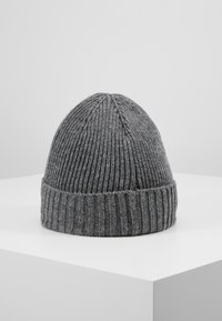 Béret en tricot gris avec des côtes verticales. Il présente un revers doublé à la base et un sommet arrondi. Texture douce, adaptée aux temps froids.