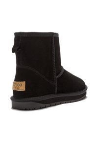 Crna gležnjača od brušene kože s okruglim vrhom, ojačanim šavovima, trakicom za povlačenje i gumenim potplatom. Na peti se nalazi oznaka marke.