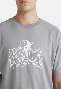 Light gray cotton t-shirt featuring white text and graphic design with a yin-yang symbol. Short sleeves, crew neck, relaxed fit.