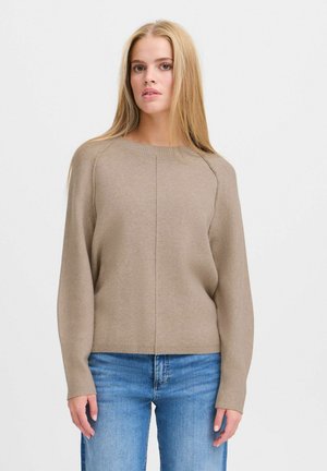 Brown knitted sweater with long sleeves, round neckline, slightly loose fit, ribbed cuffs, and seam detailing. Paired with blue jeans.