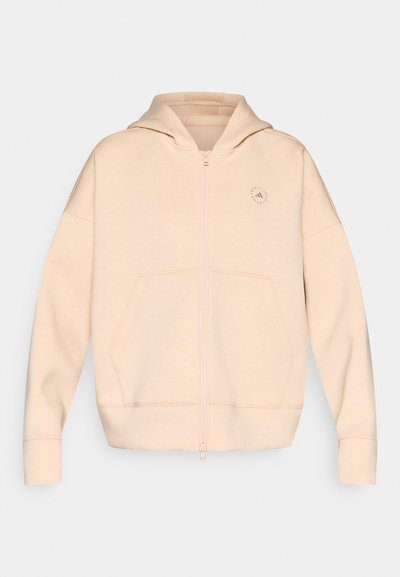 Μπεζ φούτερ με φερμουάρ, κατασκευασμένο από μαλακό υλικό, με κουκούλα, δύο μπροστινές τσέπες και διακριτική λεπτομέρεια λογότυπου στο στήθος.