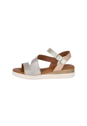 Sandalia de mujer con punta abierta, tiras de cuero metálico plateado y beige, hebilla ajustable, plantilla acolchada marrón y suela de goma blanca.