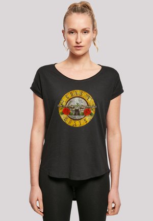 Black short-sleeve t-shirt featuring a circular graphic with "Guns N' Roses," roses, and a skull, in yellow and gray tones. Soft fabric, relaxed fit.