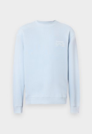 Ljusblå sweatshirt med rund halsringning, ribbade muddar och fåll. Har vit text på bröstet som visar varumärke och adressuppgifter.