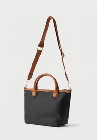 Černá taška přes rameno z nylonu s hnědými koženými uchy a popruhem, s doplňky ve zlaté barvě a zapínáním na zip. Hladká textura, obdélníkový tvar.