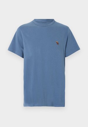 T-shirt bleu à manches courtes avec col rond, doté d'un petit logo brodé représentant un élan marron et jaune sur la poitrine gauche.
