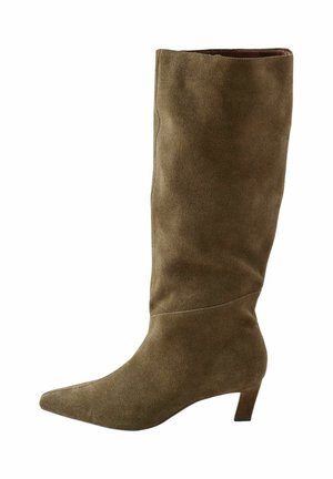 Bottes en daim marron montantes, à bout pointu et à petit talon. Le design présente une texture lisse et des détails de couture subtils.