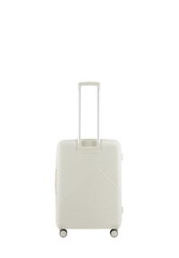 Hard-shell suitcase in white, featuring diagonal grooves, retractable handle, and four spinner wheels for easy maneuverability.