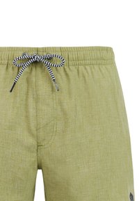Shorts vert clair avec ceinture élastique et cordon noir et blanc en zigzag noué en un nœud à l'avant au centre.
