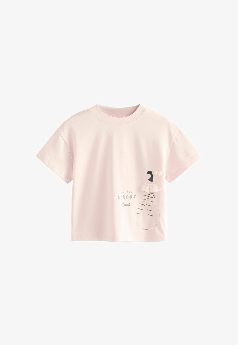 Lichtroze T-shirt met korte mouwen met een ballerina-figuur die balanceert op een bal en de tekst "to the CIRCUS" met een pijl die naar links wijst.