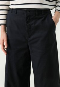 Navy cotton trousers featuring a straight cut, front pockets, and a button closure. The fabric has a smooth texture with minimal sheen.